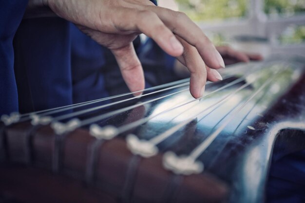 Manos cortadas de una persona que toca la guitarra
