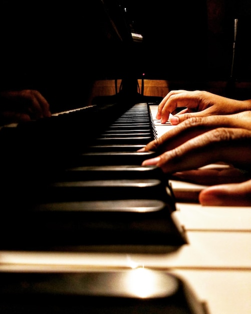 Foto manos cortadas de una persona tocando el piano