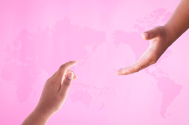 Foto manos cortadas de personas extendiendo la mano contra el mapa sobre un fondo rosa