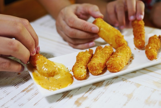 Foto manos cortadas de personas sosteniendo nuggets de pollo en un plato