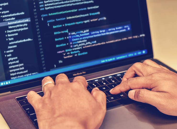 Foto manos cortadas de un programador de computadoras que usa una computadora portátil en la mesa