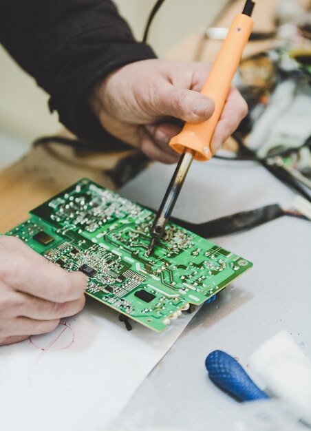 Foto manos cortadas reparando el chip de la computadora