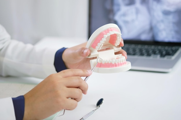 Manos cortadas sosteniendo equipos dentales en la mesa