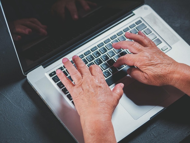 Manos cortadas usando una computadora portátil en la mesa