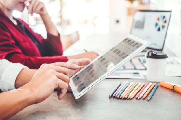 Foto manos cortadas usando una tableta digital por un colega en la oficina creativa