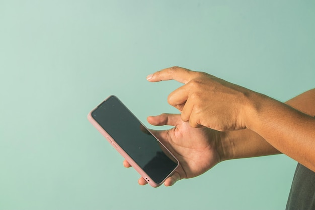 Foto manos cortadas usando teléfono móvil contra el cielo