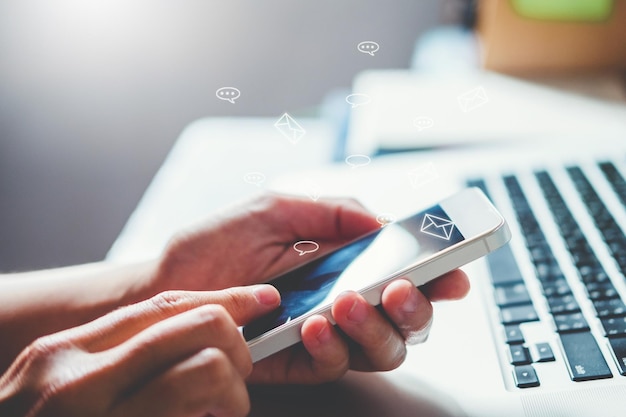 Manos cortadas usando teléfono móvil con iconos