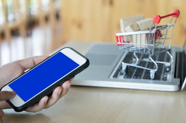 Manos cortadas usando teléfono móvil en la mesa