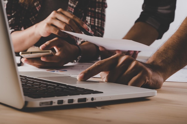 Las manos cortadas de usar la computadora portátil en la mesa