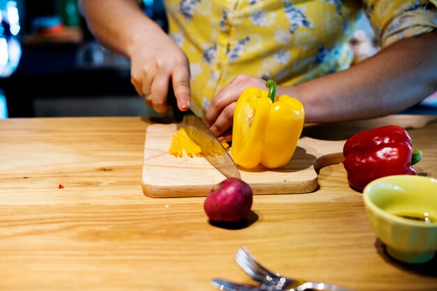 Manos cortando y preparando para cocinar.