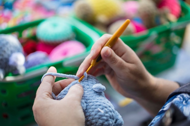 Manos de una costurera crochet Dedos femeninos tejer un juguete Artesanía hecha a mano