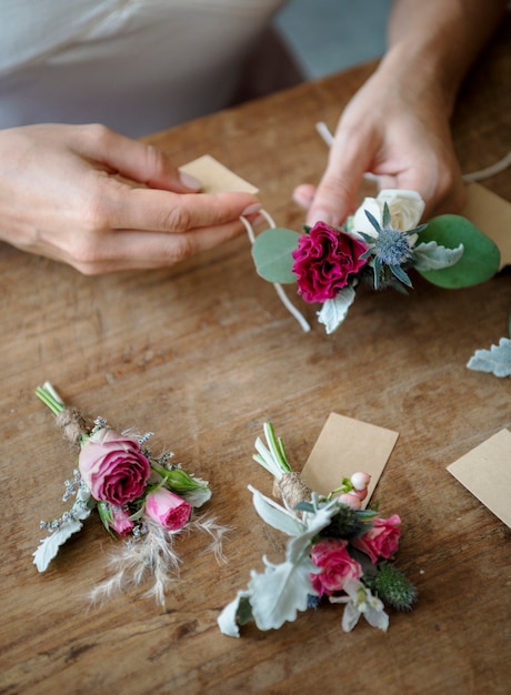 Foto manos creando boutonnieres con etiquetas de papel