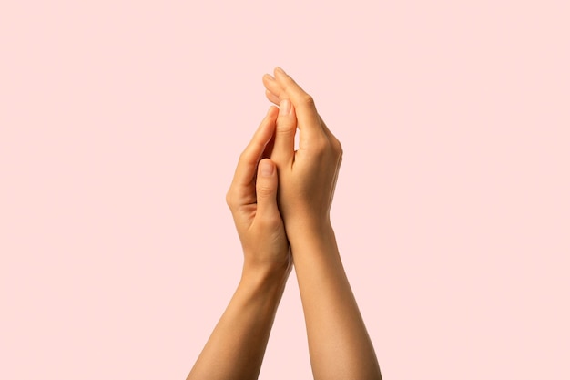 Foto manos cuidados de perto de beleza hidratada mãos isoladas em fundo rosa