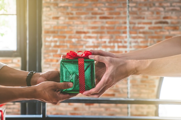 Manos dando y recibiendo un regalo