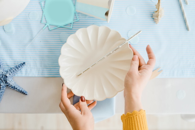 Manos de decorador. Mujer sirviendo mesa para cumpleaños o fiesta de baby shower. Primer plano, enfoque selectivo