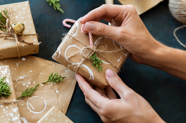 Foto manos decorando regalo de navidad con bastón de caramelo