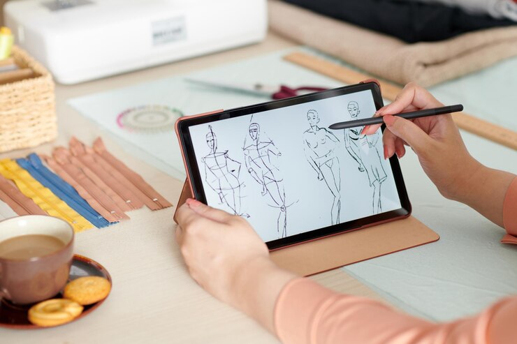 Foto manos de diseñador de moda dibujando bocetos en una tableta con lápiz digital