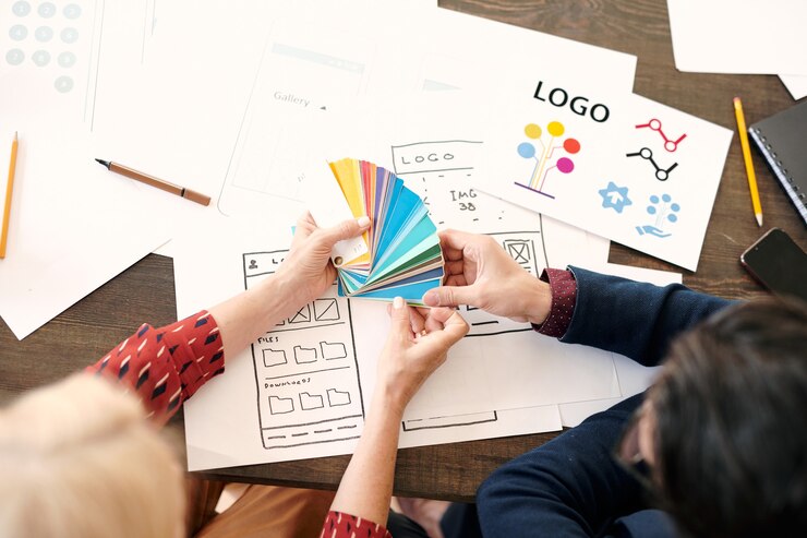 Foto manos de diseñadora madura con paleta consultando con un colega masculino sobre qué color elegir para su nuevo proyecto