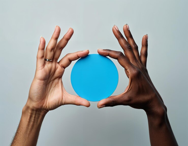 Foto manos diversas sosteniendo un objeto azul delante de ellos en un fondo plano