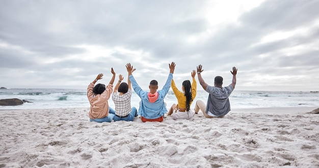 Manos de diversidad o amigos en la arena de la playa para relajarse en vacaciones uniéndose en la naturaleza juntos Vista posterior grupo de hombres y mujeres que se relajan en el mar disfrutan viajando en viajes oceánicos en Miami Florida