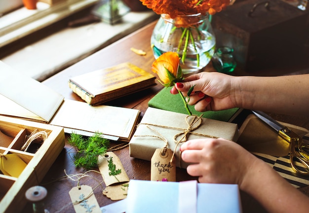 Manos diy envolver caja de regalo en mesa de madera