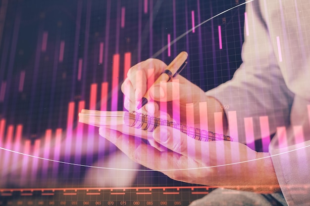 Manos de doble exposición con el gráfico del mercado de valores