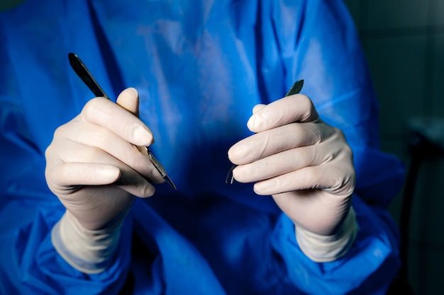 Foto manos del doctor en guantes médicos. instrumentos para realizar operaciones quirúrgicas en los ojos. de cerca. concepto medico