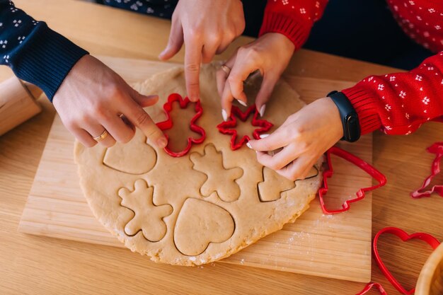 Manos de dos amantes hombre y mujer haciendo galletas caseras en el