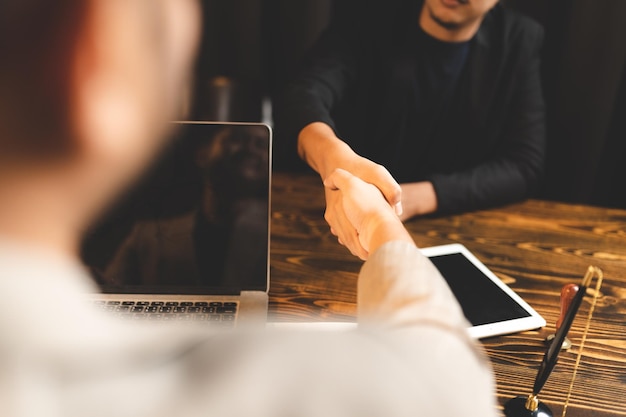 Manos de dos hombres de negocios dándose la mano y sellando una sociedad