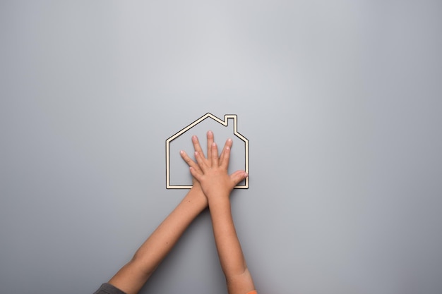 Foto manos de dos niños dentro del marco de una casa