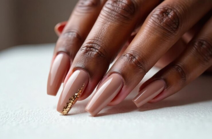 Manos elegantes de cerca con mousse de mocha uñas de color adornadas con diseños de papel dorado