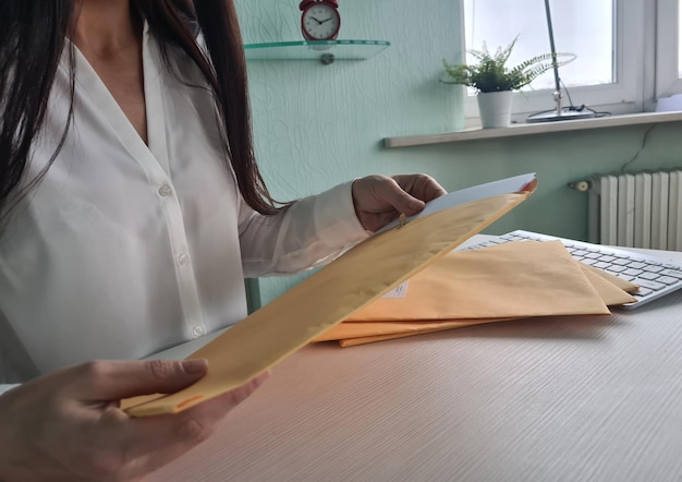 Manos de empresaria abriendo sobre con papel blanco sacar documento para leer