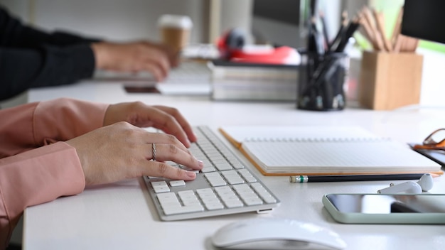 Manos de empresaria de tiro recortada escribiendo en el teclado.