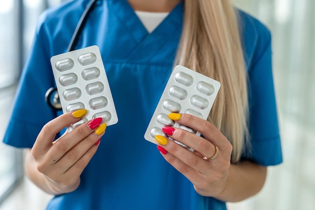 Manos de enfermera sosteniendo paquetes de pastillas en las manos