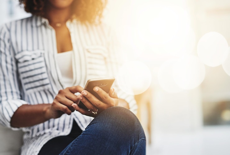 Foto manos enviando mensajes de texto en el teléfono navegando en las redes sociales o buscando en internet mientras espera una entrevista de trabajo o una nueva oportunidad en la oficina creativa primer plano de una mujer de negocios que trabaja en un sitio web de inicio en tecnología
