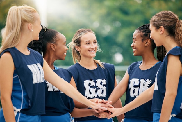 Manos del equipo de netball y motivación deportiva de las mujeres del grupo de atletas que muestran apoyo feliz en el trabajo en equipo Grupo de ejercicio femenino con diversidad y sonrisa lista para un partido de entrenamiento al aire libre con felicidad