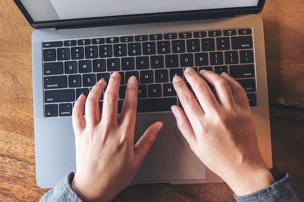 manos escribiendo en la computadora portátil