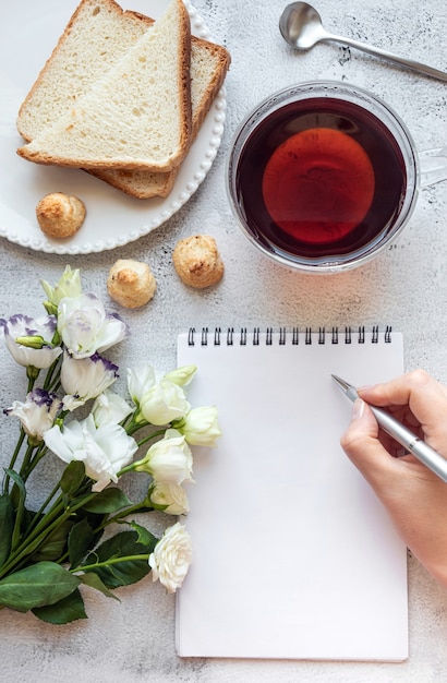 Manos escribiendo en un espacio de copia de ajuste de desayuno de Bloc de notas