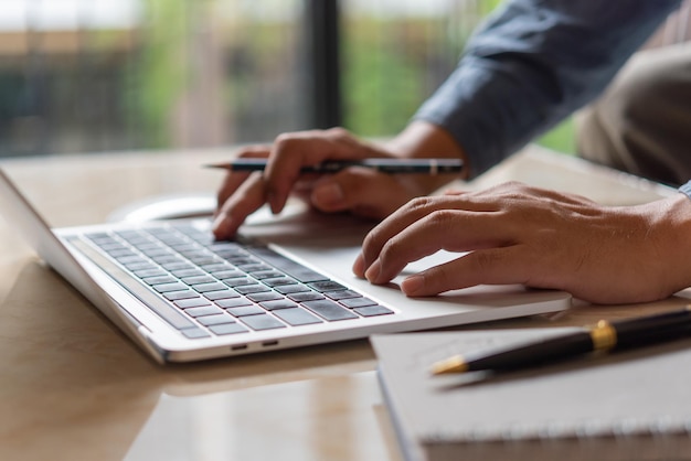 Foto manos escribiendo en un teclado empresario trabajando en un nuevo proyecto con una computadora portátil búsqueda de trabajo búsqueda de información en internet compras en línea