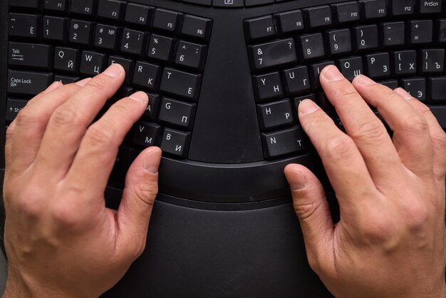 Las manos escribiendo en un teclado mecánico en un espacio de trabajo que mejora la productividad y la concentración
