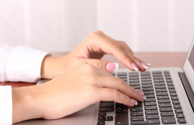 Foto manos escribiendo en el teclado del portátil de cerca