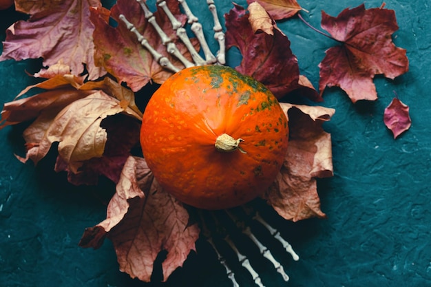 Manos esqueléticas con calabaza de Halloween