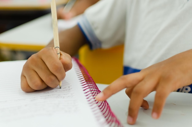 Manos de un estudiante de escuela pública haciendo tareas escolares en un cuaderno Ciudad de Salvador Bahia