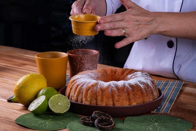 manos femeninas aplicando azúcar en polvo en el pastel