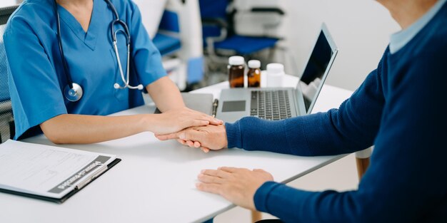 Foto manos femeninas asiáticas tocando manos femeninas viejas manos que ayudan a cuidar del concepto de ancianos en la oficina del hospital