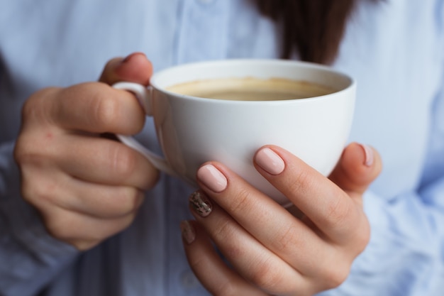 Manos femeninas con bebida de café