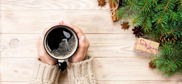 Manos femeninas con café con decoración de Navidad