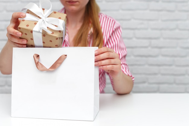 Manos femeninas con caja de regalo.