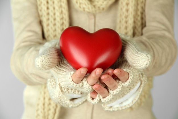 Manos femeninas con corazón rojo, primer plano