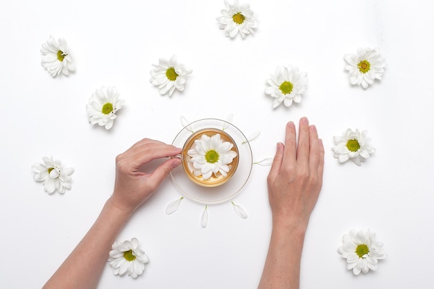 Manos femeninas con crema y hermosas flores sobre fondo claro